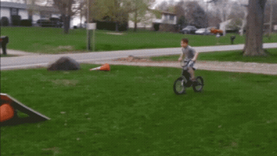 Boy Riding Bike On Grass GIF