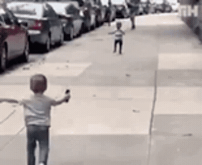 Boy Riding Scooter Down Sidewalk GIF