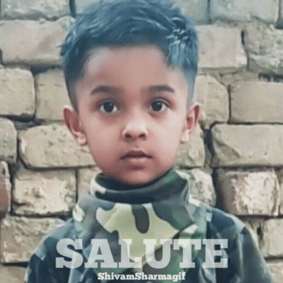 Boy Saluting In Front Of Brick Wall GIF