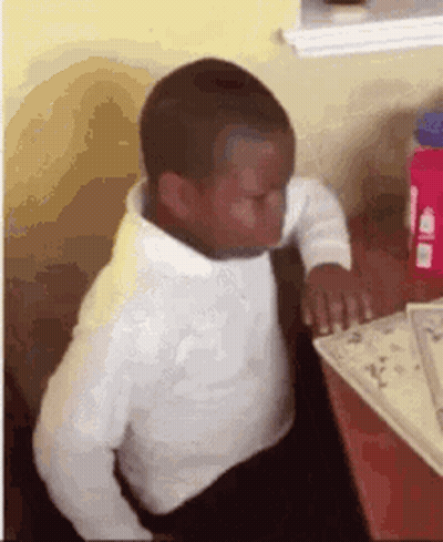 Boy Sitting At Table Reading Book GIF