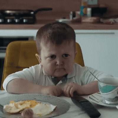 Boy Sitting At Table With Food And Remote GIF