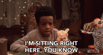 Boy Sitting At Table With Gingerbread House Says I'm Sitting Right Here You Know GIF
