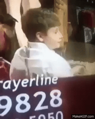 Boy Sitting In Front Of Prayerline 9828 Sign GIF