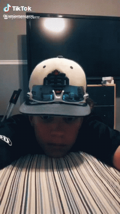 Boy Wearing Hat And Sunglasses Lying On Bed GIF