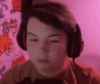 Boy Wearing Headphones Looking At Phone GIF