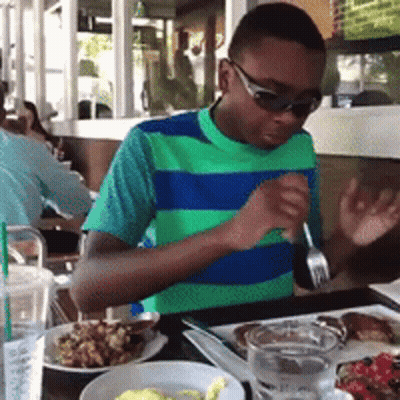 Boy Wearing Sunglasses Sitting At Table GIF