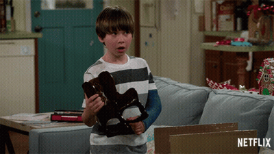 Boy With Arm Cast Holding Toy In Front Of Netflix Box GIF
