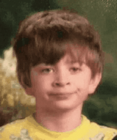 Boy With Big Hair Smiling In Yellow Shirt GIF