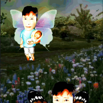 Boy With Butterfly Wings Holding Baby In Field GIF