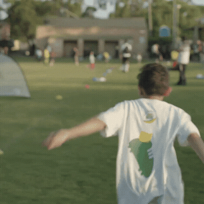 Boy With Green And Yellow Design Shirt Running In Field GIF