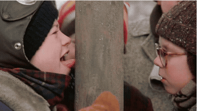 Boy With Helmet Sticking Tongue Out At Girl With Glasses GIF