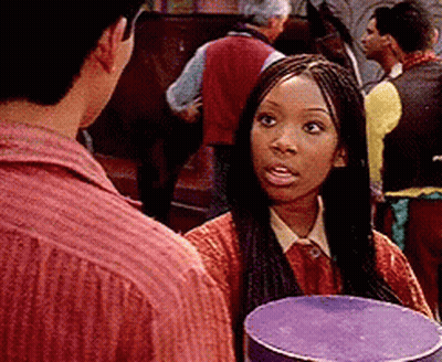 Braided Woman Holding Purple Box Talking To Man GIF