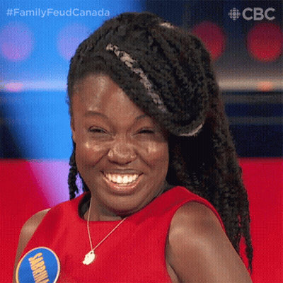 Braided Woman Smiling In Red Shirt With Jamaica Badge GIF