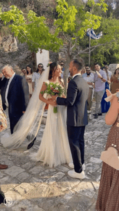 Bride And Groom Posing In Front Of Crowd GIF