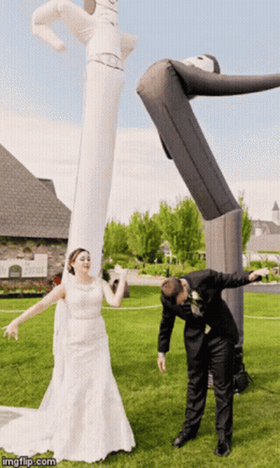 Bride And Groom Posing With Large Inflatable Man GIF