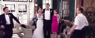 Bride And Groom Posing With Wedding Guests On Porch GIF