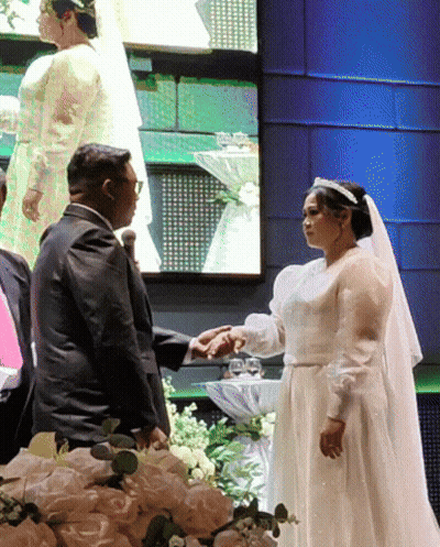 Bride And Groom Standing In Front Of Large Screen GIF