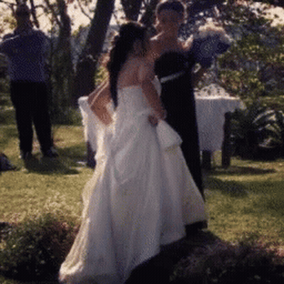 Bride In White Wedding Dress Standing In Grass GIF