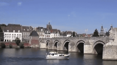 Bridge Over Water With Boat In Foreground GIF