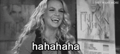 Britney Spears Is Laughing In A Black And White Photo While Standing In Front Of A Sign . GIF