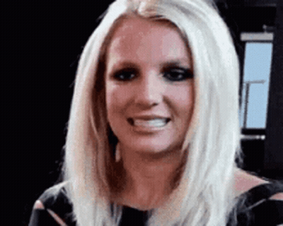 britney spears is smiling and looking at the camera .