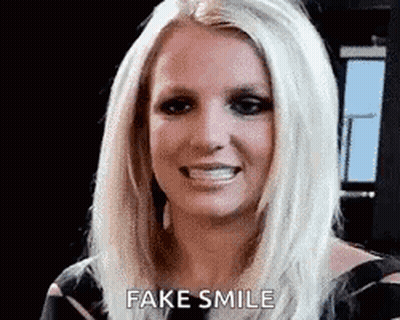 Britney Spears Is Smiling And Making A Fake Smile With Her Mouth Open . GIF