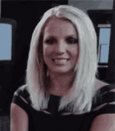 Britney Spears Is Smiling And Wearing A Black Dress . GIF
