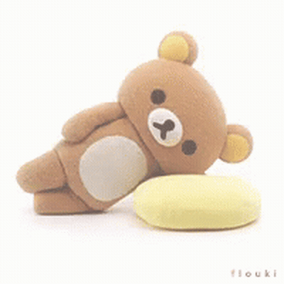 Brown Teddy Bear Laying On Yellow Pillow GIF