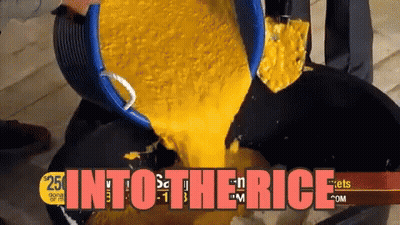 Bucket Of Yellow Liquid Poured Into Black Pan Into The Rice GIF