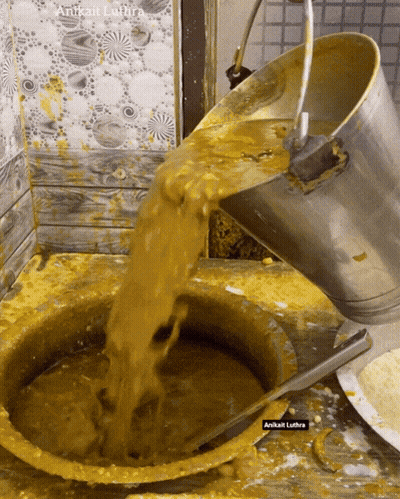 Bucket Pouring Yellow Liquid Into Bowl Labeled Anitkat Lutra GIF