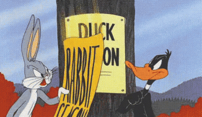 Bugs Bunny And Daffy Duck Standing Next To Duck Rabbit Sign GIF