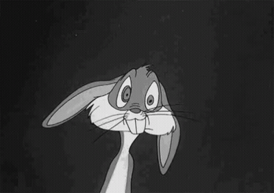 Bugs Bunny From The Looney Tunes Cartoon Is Sitting Down With His Hands Folded In Front Of His Face . GIF