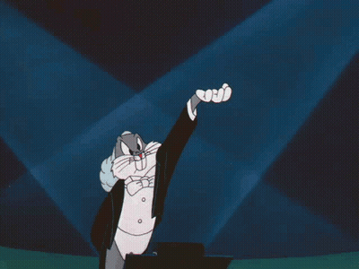 Bugs Bunny Is Wearing A Tuxedo And Bow Tie And Raising His Hand GIF
