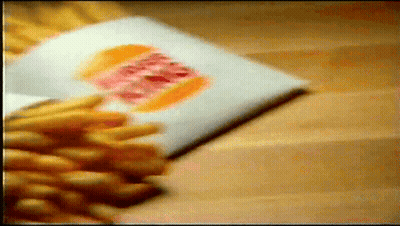 Bunch Of French Fries On Wooden Table GIF