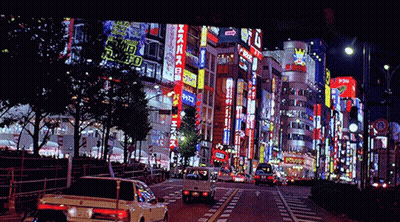 Busy City Street At Night With Sign Saying A GIF