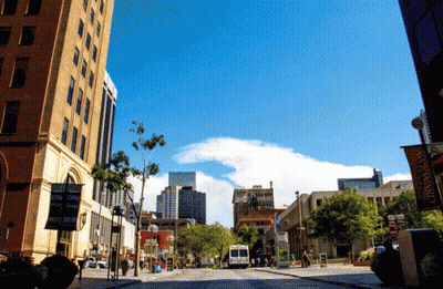 Busy City Street With Downtown Sign GIF