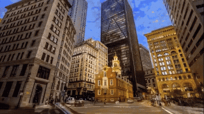 Busy City Street With Tall Buildings And Clock Tower GIF