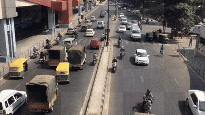 Busy Street With Cars And Motorcycles And Sign Saying A GIF