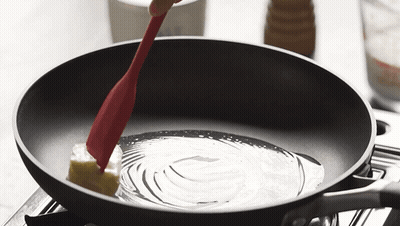 Butter Being Stirred In Frying Pan With Red Spatula GIF