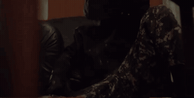 Camouflage Man Sitting At Table With Gun GIF
