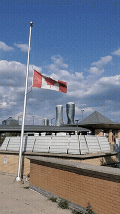 Canadian Flag Flying In Front Of Brick Building GIF