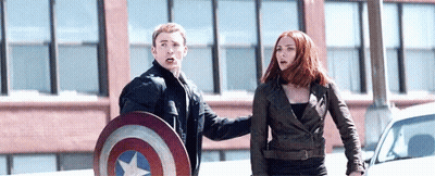 Captain America And Black Widow Are Standing Next To Each Other On The Street . GIF