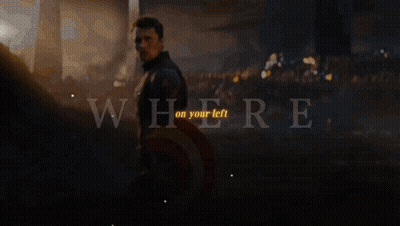 Captain America Stands In Front Of A Crowd With The Words " Where On Your Left " Above Him GIF