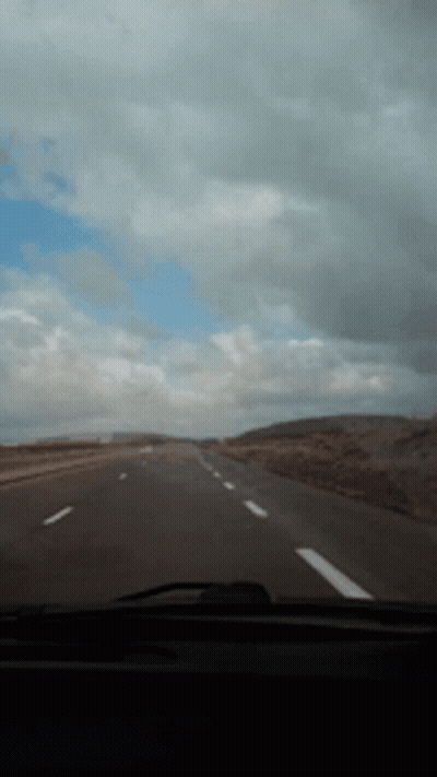Car Driving Down Highway With Cloudy Sky GIF