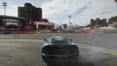 Car Driving Down Road With Building And Hot Air Balloon GIF