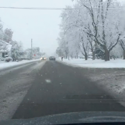 Car Driving Down Snow Covered Street GIF