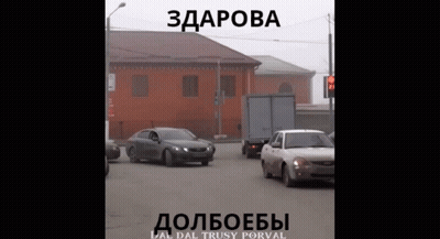 Car Driving Down Street In Front Of Building Saying Здорова GIF