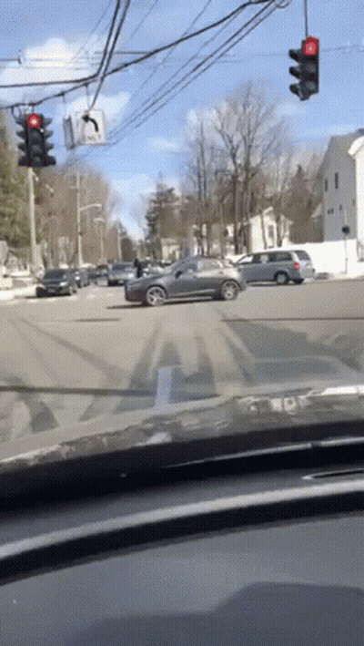 Car Driving Through Busy Intersection With Red Light GIF