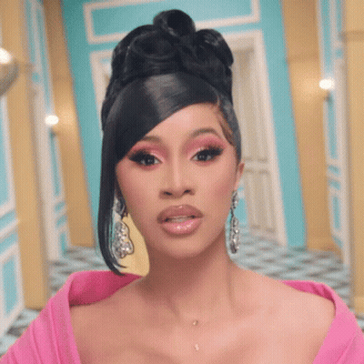 Cardi B Wearing A Pink Dress And Earrings Looks At The Camera GIF