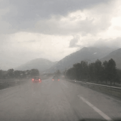 Cars Are Driving Down A Highway In The Rain GIF